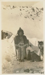 Image of Eskimo [Inughuit] girl - front view with dog and puppies